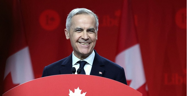 An aged Caucasian male smiles at a podium