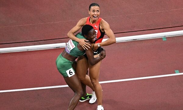 two athletes in emotional embrace after a race