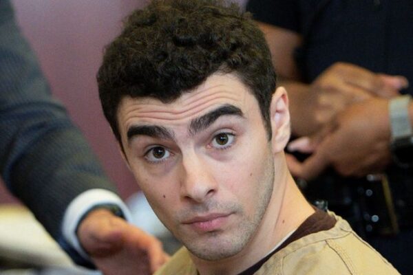 Caucasian male in prison outfit appearing in court